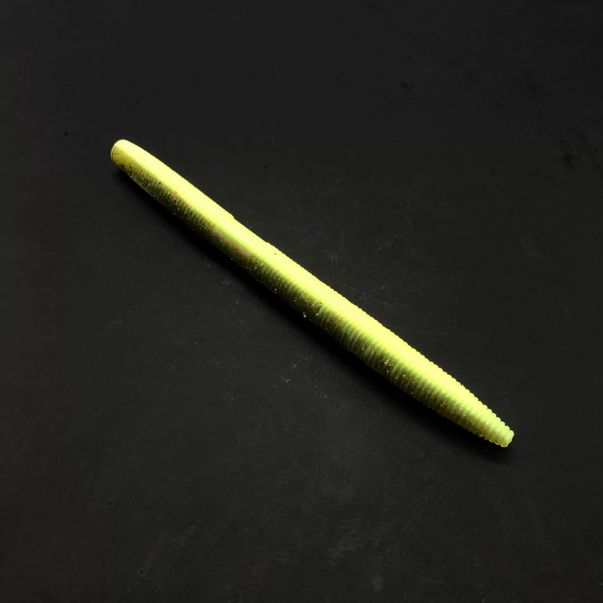 Soft plastic stick bait worm, neon yellow-green, speckled
