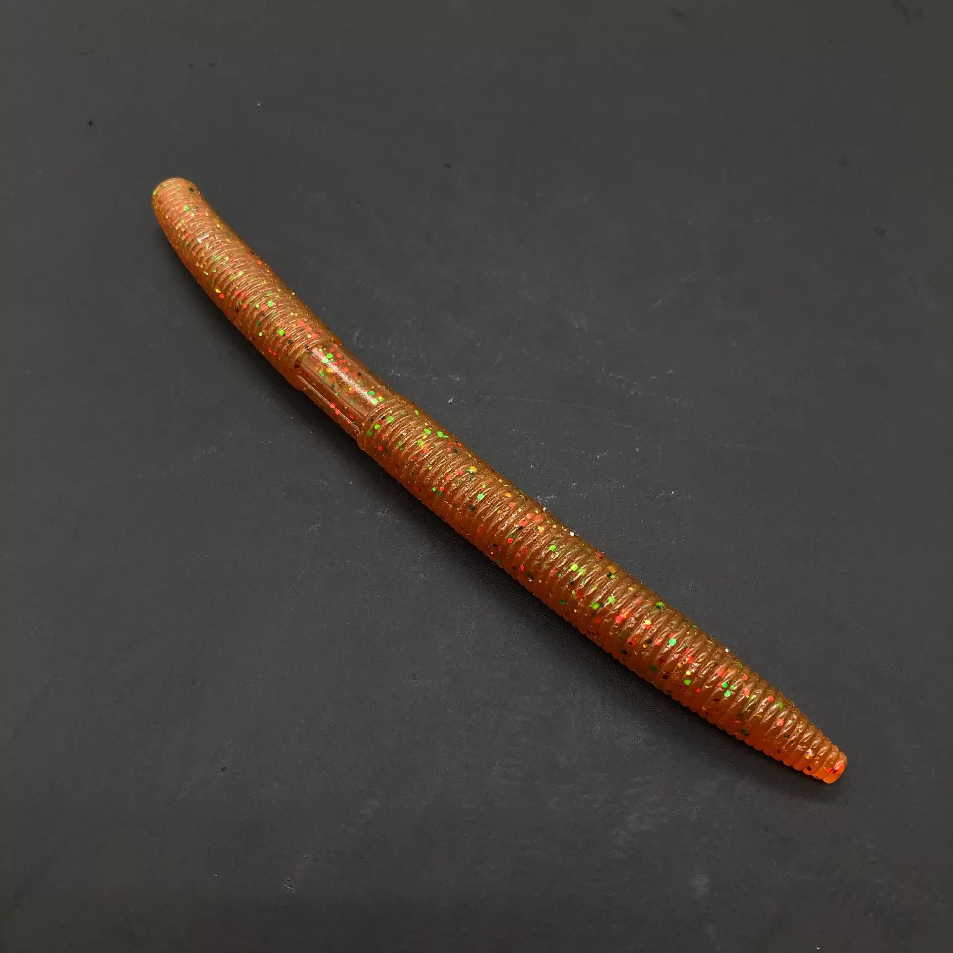 Soft plastic stick bait worm, brown-orange with glitter speckles