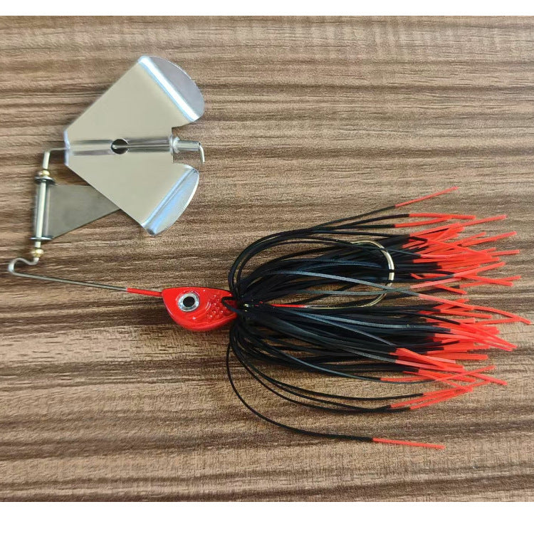 Skirted bladed jig lure with black and orange strands and red lure head