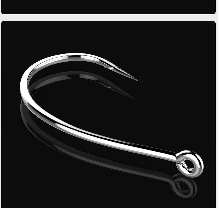 Silver barbed fishing hook with circular eye, angled close-up