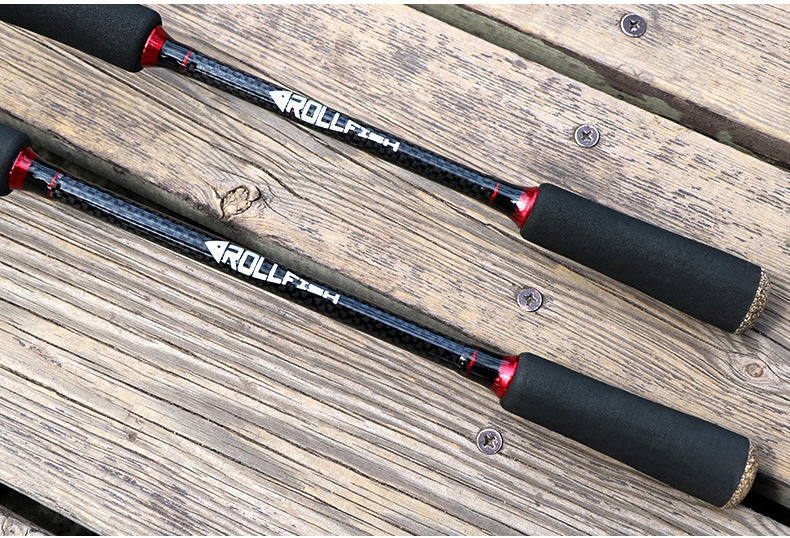 Two black fishing rods with red trim resting on a wooden surface